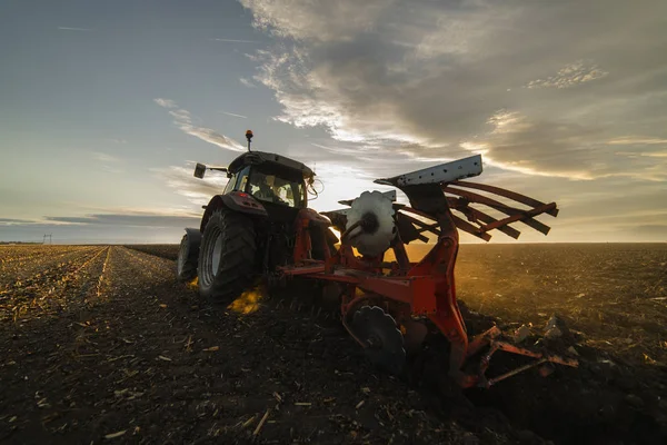 Tractor ploegen velden bij zonsondergang — Stockfoto