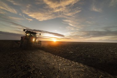 Gün batımında traktör sürme alanları