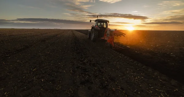 Tractor ploegen velden bij zonsondergang — Stockfoto