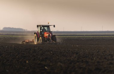 Çiftçi bahara hazır bir traktörle tarlasını hazırlıyor..