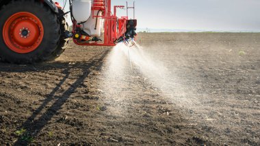 Traktör tarlada böcek ilacı püskürtüyor. 