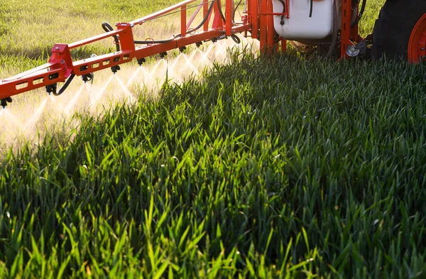緑の畑に農薬を散布するトラクター — ストック写真