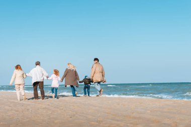 family walking at seashore clipart