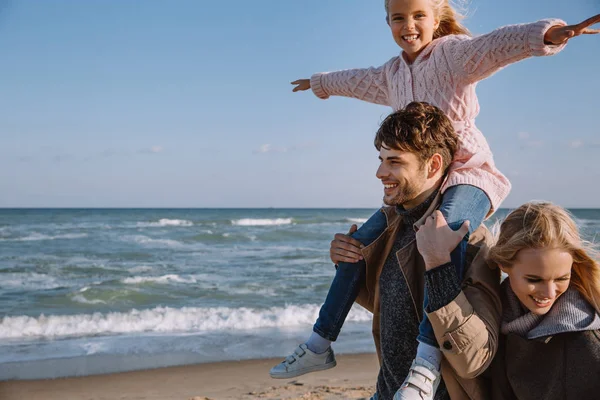 Семья со счастливой дочерью на берегу моря — стоковое фото
