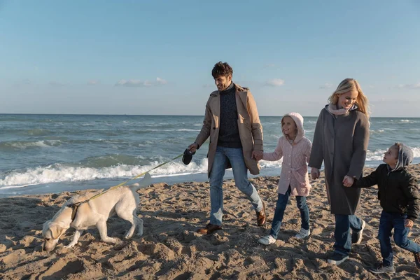 Familia paseando con el perro en la playa — Foto de Stock