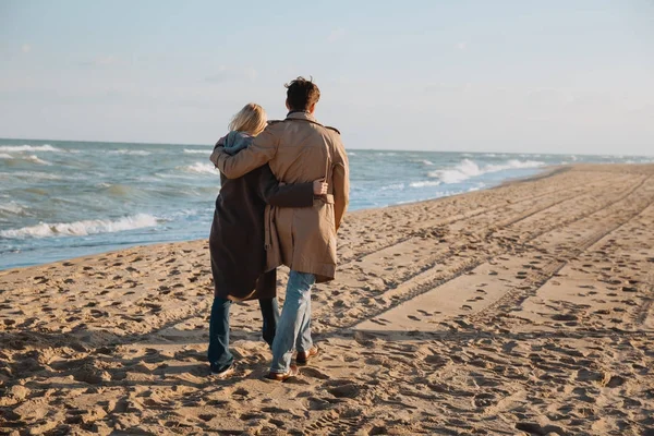 Couple hugging and walking at seaside — Stock Photo, Image