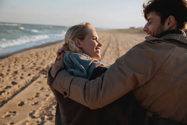 Smiling couple embracing on seashore — Free Stock Photo