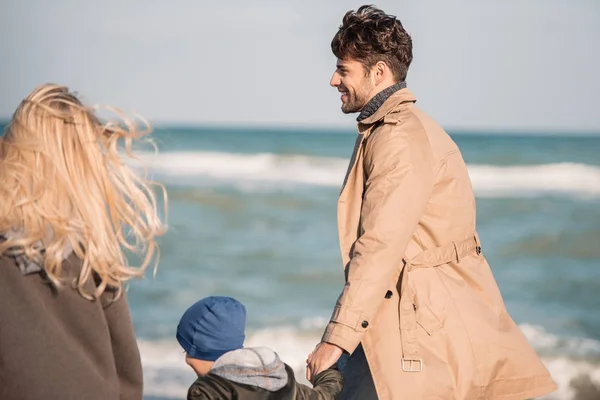 Parents avec fils marchant sur le bord de mer — Photo