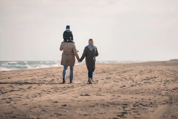 Parents and son walking on seashore — Stock Photo, Image