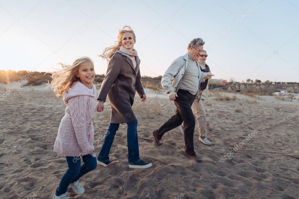multigenerational family walking on beach