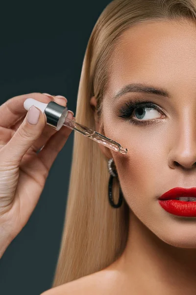 Beautiful Blonde Girl Applying Treatment Pipette Face Isolated Black — Stock Photo, Image