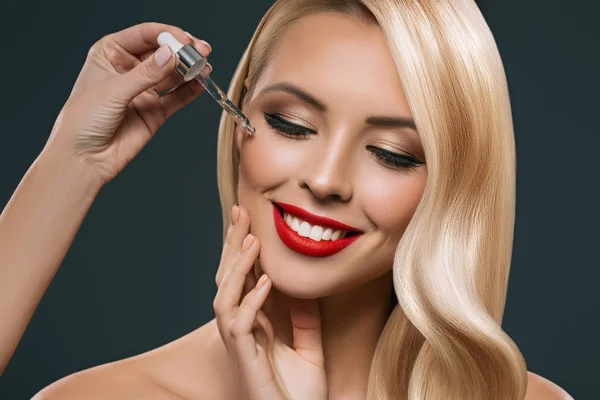 Beautiful Blonde Girl Applying Treatment Pipette Face Isolated Black — Stock Photo, Image