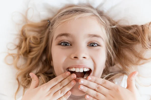 Top View Smiling Adorable Child Lying Bed Covering Mouth Hands — Stock Photo, Image