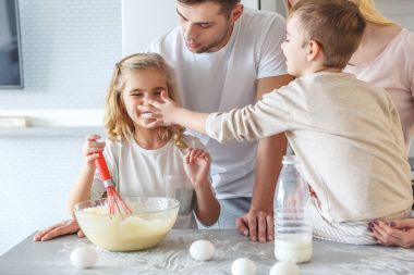 Genç aile birlikte kahvaltı yemek yaparken oynamaya