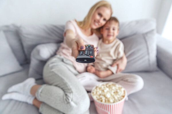 close-up shot of mother and son using remote control for tv