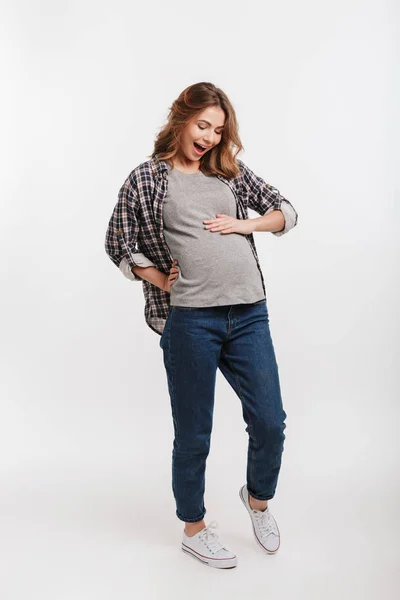 Podekscytowana Kobieta Ciąży Patrząc Brzuch Szarym Tle — Zdjęcie stockowe