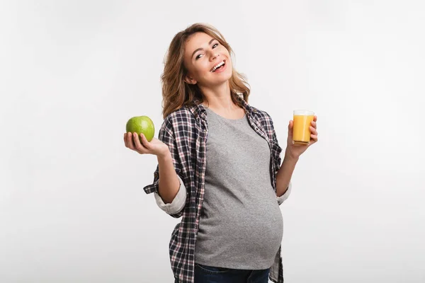 快乐怀孕的妇女拿着苹果和玻璃的果汁隔离在白色 — 图库照片