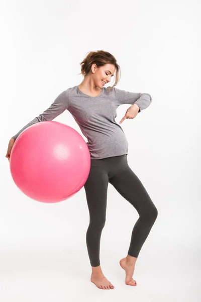Mujer Embarazada Sonriente Sosteniendo Pelota Forma Señalando Vientre Aislado Blanco —  Fotos de Stock