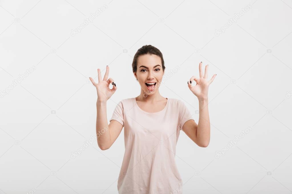 happy girl showing ok gesture with two hands isolated on white