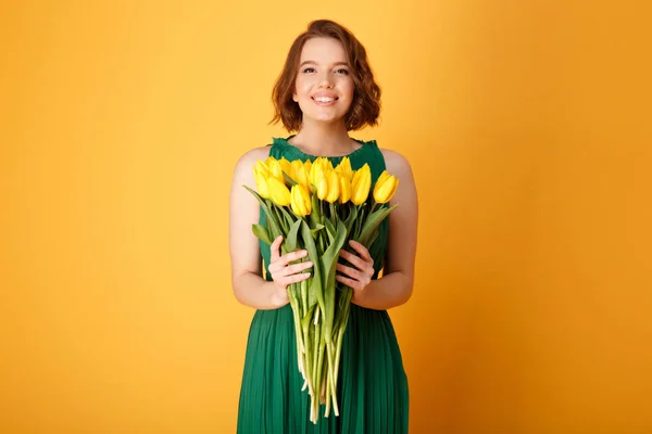 Portrait Smiling Woman Holding Bouquet Yellow Tulips Isolated Orange — Stock Photo, Image