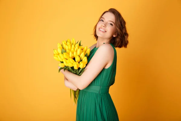 Widok Boku Piękną Kobietą Bukiet Żółtych Tulipanów Patrząc Kamery Pomarańczowym — Zdjęcie stockowe