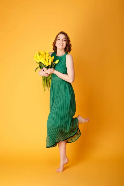 Красива Молода Жінка Зеленій Сукні Букетом Жовтих Весняних Тюльпанів Ізольовані — стокове фото