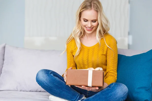Schöne Lächelnde Junge Frau Mit Geschenkbox Während Sie Hause Auf — Stockfoto