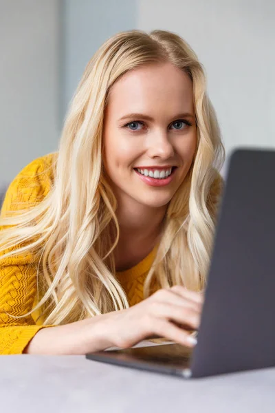 Όμορφη Νεαρή Ξανθιά Γυναίκα Χρησιμοποιώντας Φορητό Υπολογιστή Και Χαμογελά Στη — Δωρεάν Φωτογραφία