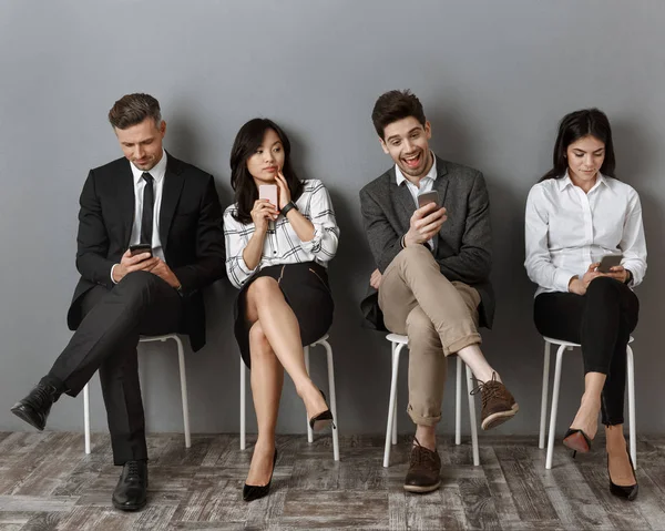 Interracial Business People Formal Wear Smartphones Waiting Job Interview — Free Stock Photo