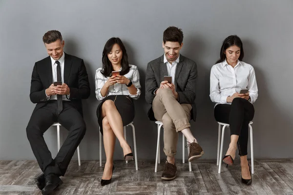 Smiling Interracial Business People Using Smartphones While Waiting Job Interview — Stock Photo, Image