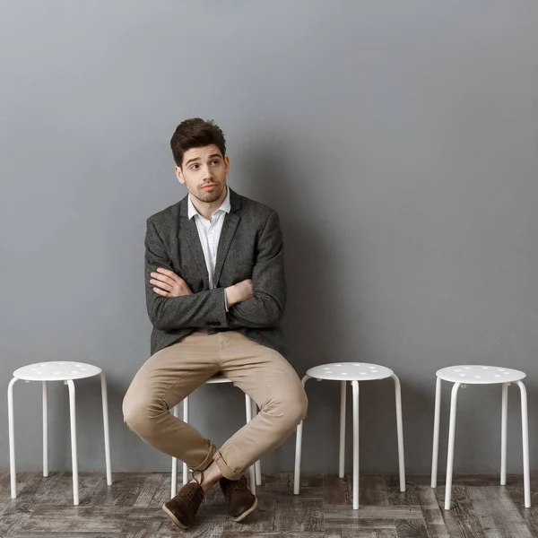 Zamyšlený Podnikatel Čekání Pohovor Židli Proti Šedé Zdi — Stock fotografie zdarma