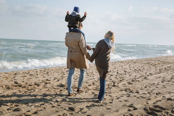 Padres con hijo en la orilla del mar - foto de stock