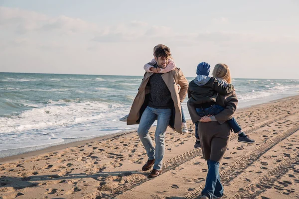 Eltern huckepack ihre Kinder — Stockfoto