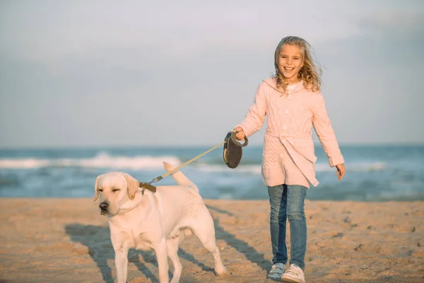 Kid walking with dog at seaside — Stock Photo