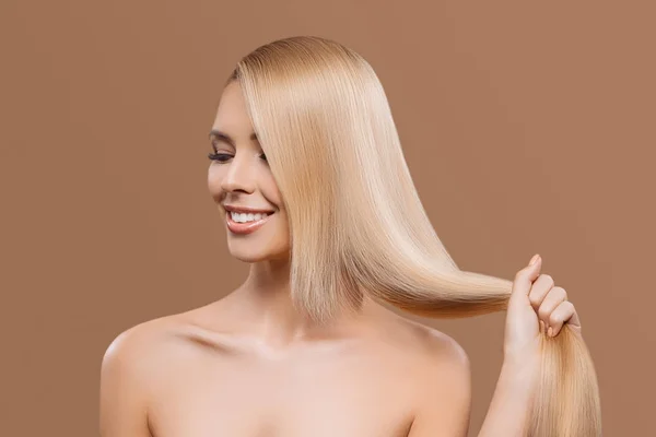 Ritratto di bella bionda dai capelli lunghi ragazza con gli occhi chiusi isolati su beige — Foto stock