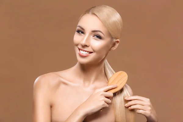 Woman combing long hair — Stock Photo