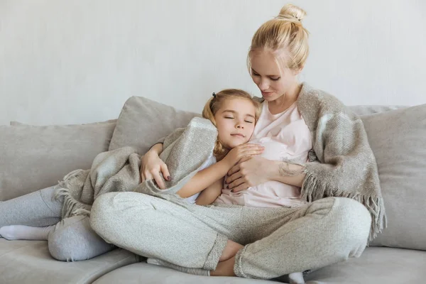 Cheerful daughter sleeping on pregnant mother belly — Stock Photo