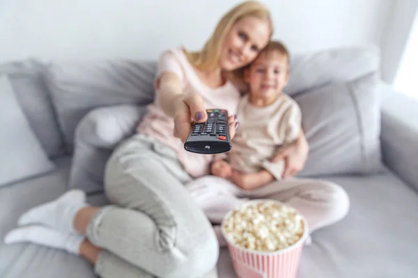 Primo piano di madre e figlio utilizzando il telecomando per la tv — Foto stock