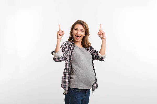 Portrait de femme enceinte heureuse pointant vers le haut isolé sur gris — Photo de stock