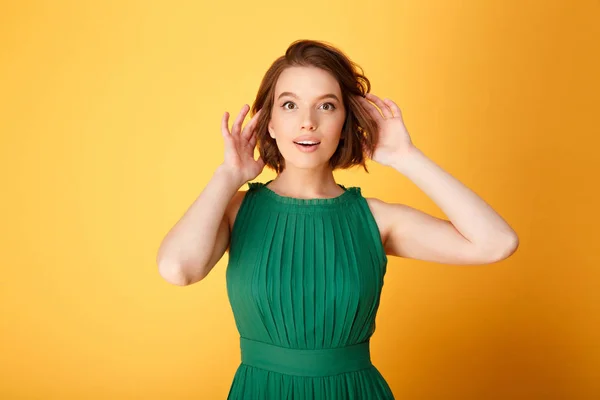 Portrait of young attractive woman looking at camera isolated on orange — Stock Photo