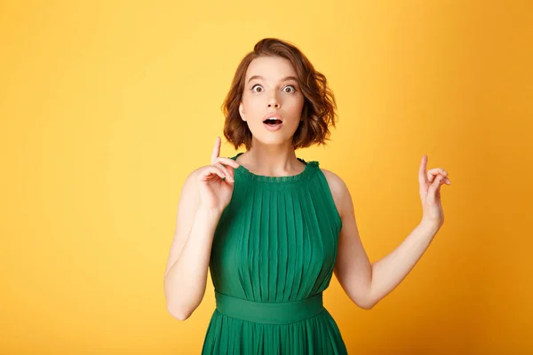 Retrato de mujer joven sorprendida teniendo idea aislada en naranja - foto de stock