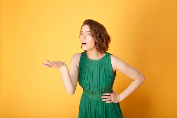 Portrait of shocked woman with outstretched arm isolated on orange — Stock Photo