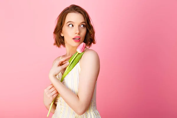 Porträt der schönen Frau im weißen Kleid mit rosa Tulpenblüte isoliert auf rosa — Stockfoto