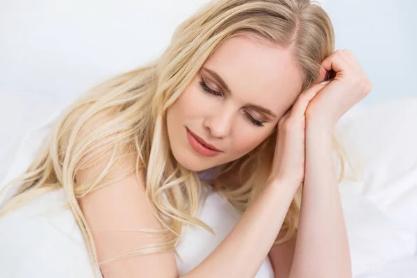 Красивая нежная блондинка с закрытыми глазами лежит на кровати — стоковое фото