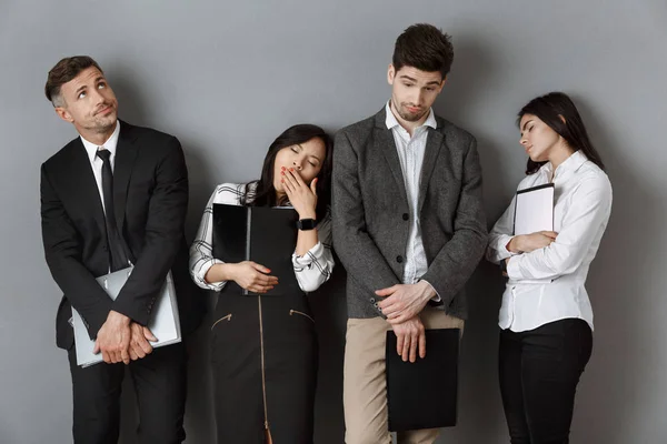 Gente de negocios multicultural esperada y cansada con carpetas y cuadernos esperando una entrevista de trabajo - foto de stock