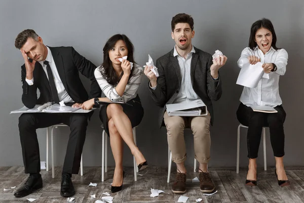 Stressati uomini d'affari multiculturali con cartelle e quaderni in attesa di un colloquio di lavoro — Foto stock