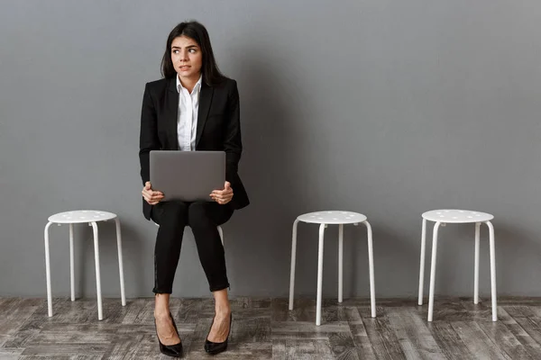 Verängstigte Geschäftsfrau im Anzug mit Laptop wartet auf Vorstellungsgespräch — Stockfoto