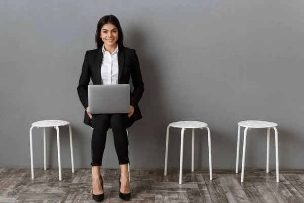 Lächelnde Geschäftsfrau im Anzug mit Laptop wartet auf Vorstellungsgespräch — Stockfoto