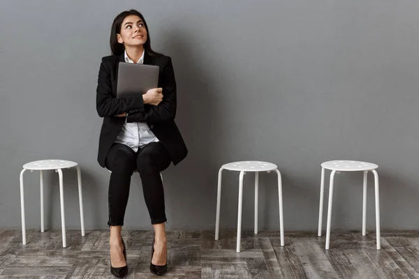 Pensativa mujer de negocios en traje con portátil a la espera de entrevista de trabajo - foto de stock