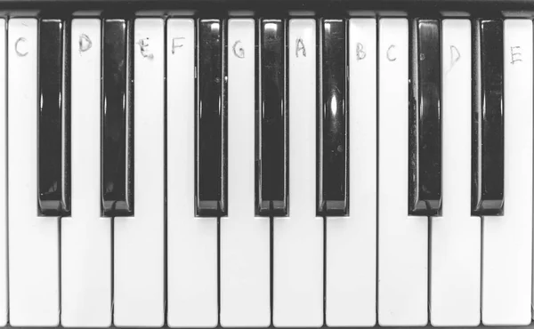 Teclas de piano blanco y negro con notas escritas, vista superior. La estafa — Foto de Stock